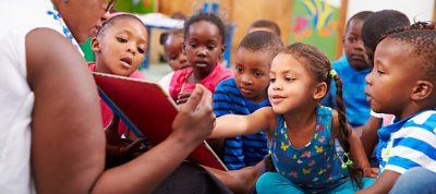 Teacher reading a book with a class of preschool children