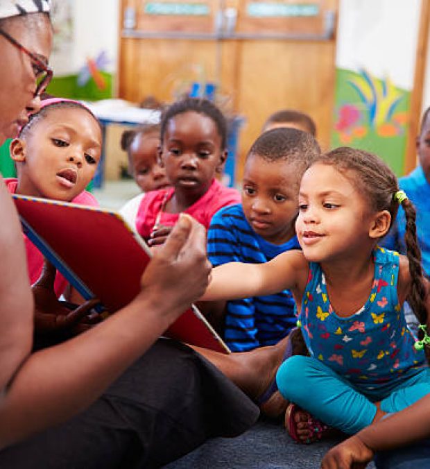 Teacher reading a book with a class of preschool children